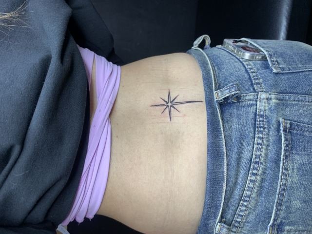 Tatuaje de destello en la espalda baja